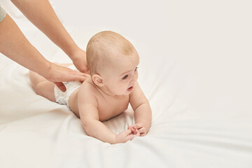 Caucasian Baby Receiving Gentle Massage On Soft White Blanket With Tender Care And Parental Love.