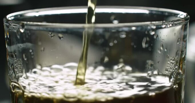 Whiskey pouring into glass tumbler.