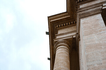Naklejka premium Large columns reach toward the sky on a historic building during an overcast day