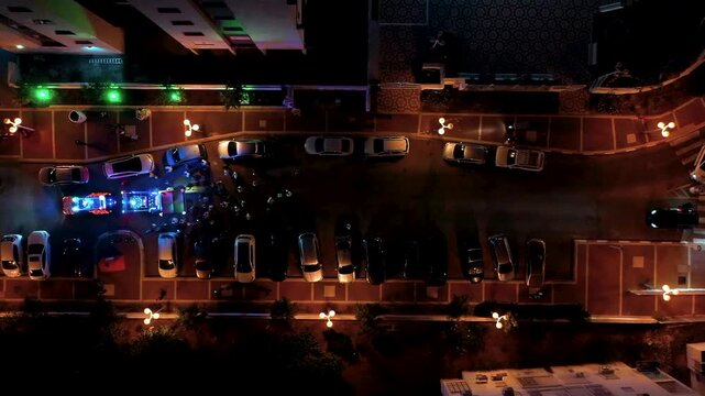 Top down aerial view of a Jewish Torah Scroll procession ceremony with a decorated canopy and crowd at night