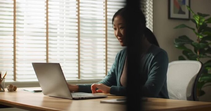 Woman working on laptop computer indoors.