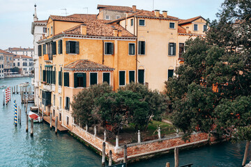 Obraz premium Building by the water in Venice showing classic architecture and greenery along the canal