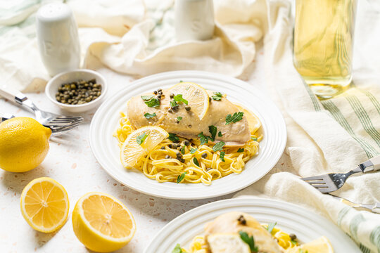 Healthy chicken piccata with lemon and capers over pasta