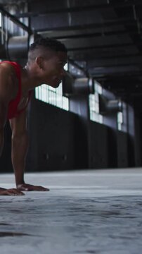 Vertical video: Man holding low pushup doing pushups for fitness in gym, blue overlay tracking reps