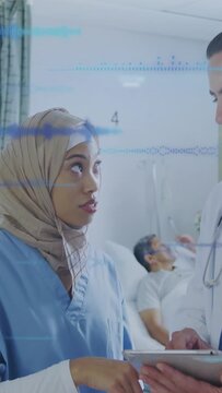 Vertical video: Nurse tapping tablet as doc holding tablet reviewing medical waveform overlay