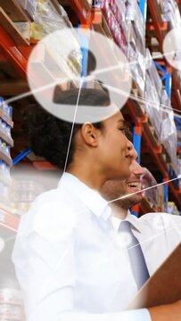 Vertical video: Stock clerk checking clipboard as peer pointing, network icons overlaying warehouse