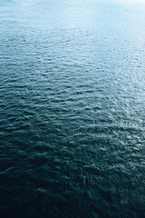 Calm rippling water surface with gentle waves and soft reflections, minimalist natural texture background.