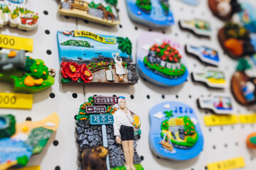 Naklejka premium Tourist gifts and Korean souvenirs from Jeju Island, Jeju-do, South Korea, tangerine hallabong figures in orange color, knitted toys, fridge magnets, key ring keychain, a local gift vendor shop market