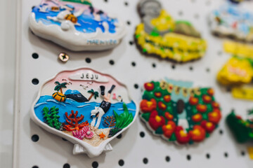 Tourist gifts and Korean souvenirs from Jeju Island, Jeju-do, South Korea, tangerine hallabong figures in orange color, knitted toys, fridge magnets, key ring keychain, a local gift vendor shop market