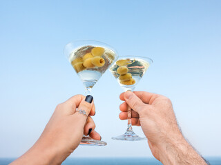 Men's and women's hands and glasses with drinks. Cruise ship deck. Against the backdrop of sea waves. Vacation and travel concept. Chill lifestyle, luxury travel. Perfect for holiday and travel themes © Svetlana