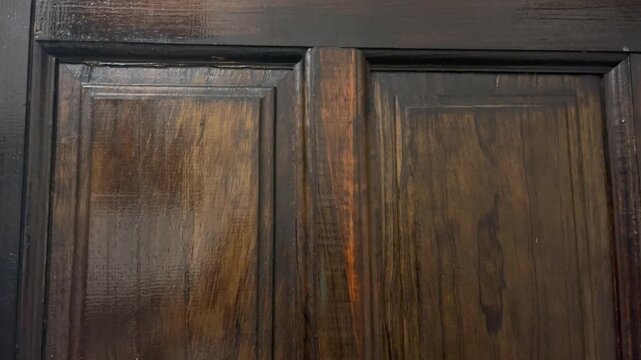close up old wooden door with wood texture. Close-up of a vintage wooden door with a pattern of rectangles and carvings that showcase the craftsmanship in a rustic, aged design made of wood material.