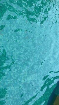 blue water texture swimming pool water. Swimming pool bottom caustics ripple and flow with waves background. Summer background. Texture of water surface. Overhead view. 