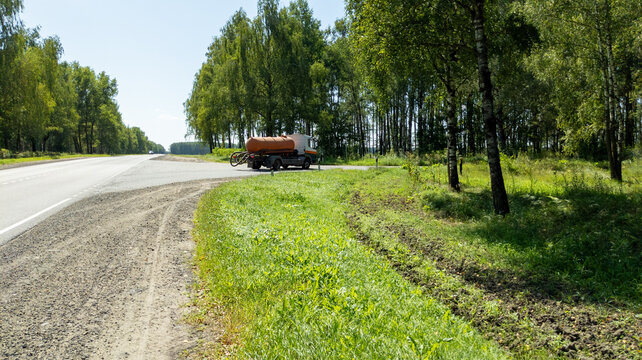 Sewage truck turns onto the road to a farm. A vacuum cleaning apparatus. Waste management and disposal policy concept