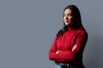 Profile portrait of beautiful confident 40 years old woman in red sweater on gray background © Valerii Honcharuk