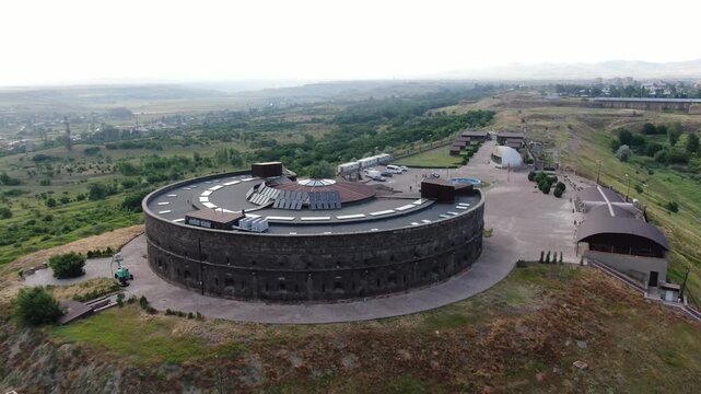 Aerial drone view of the historic Black Fortress, Sev Berd, and the Mother Armenia statue in Gyumri. The video shows the monumental architecture and the surrounding city landscape.