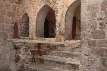 Fototapeta premium Foggy Historic Stone Street in Old Town Mardin, Turkey,Misty historic stone street in the old town of Mardin, Turkey. Traditional limestone buildings with arches and narrow alleyway disappearing into 