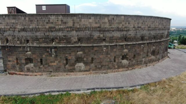 Aerial drone view of the historic Black Fortress, Sev Berd, and the Mother Armenia statue in Gyumri. The video shows the monumental architecture and the surrounding city landscape.