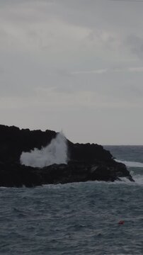 Vertical video of powerful waves crashing against volcanic rocks in Madeira, 4K 60fps