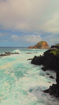 Vertical 4K turquoise waves crashing on volcanic cliffs, Porto Moniz, Madeira