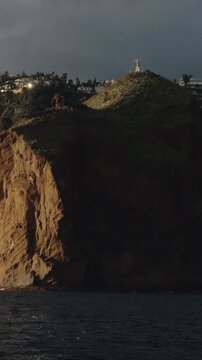 Vertical 4K view of Cristo Rei statue on a cliff at Garajau, Madeira