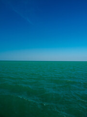 Serene tropical beach with crystal clear turquoise water, gentle waves, and a bright blue sky with fluffy white clouds. peaceful and relaxing summer scene perfect for panorama and travel concepts.