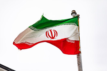 Obraz premium The flag of Iran on the flagpole on the roof of the embassy building