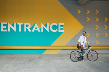 Man smiling with bicycle near entrance mural © Zamrznuti tonovi