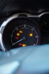 Close-up of a car dashboard with multiple warning lights illuminated, including check engine, battery, and oil pressure icons, signifying mechanical trouble. © Gaston