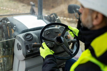 Construction worker hands on steering wheel of excavator cabin © zphoto83