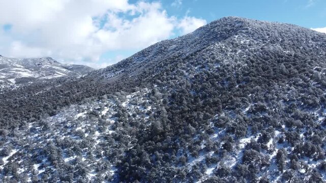 Light snow covered foothill mountains