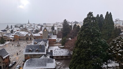 snow in Bariloche's main square, with Alpine-inspired architecture and the cathedral tower in the background. San Carlos de Bariloche, Patagonia, Argentina. Andes Mountains