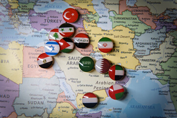 Fototapeta premium Political map of the Middle East featuring multiple national flag pins on various countries, representing regional geopolitics, international relations, and middle eastern territory concept