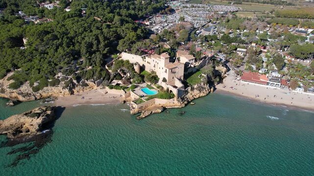 Backward reveal aerial shot of Tamarit castle on sunny day. Tamarit, Tarragona, Spain.