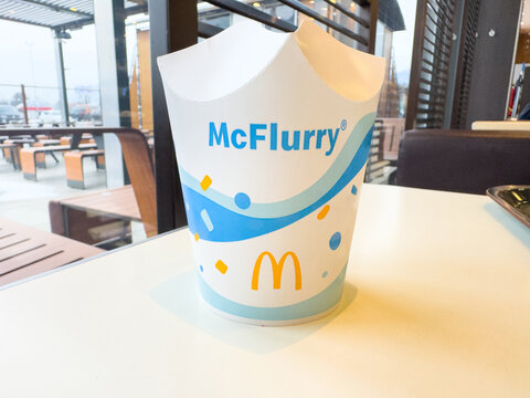 Villach, Austria - January 29, 2026: McFlurry dessert cup on a table inside a McDonald's restaurant with outdoor seating visible through the window