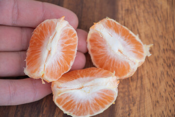 Peeled Tangerine Segments in Hand - Fresh Citrus Fruit Close Up
