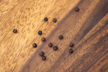 Black Peppercorns on Wooden Surface - Natural Spice Background