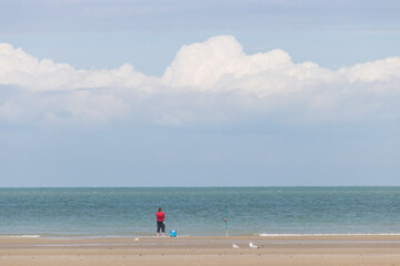 Obraz premium La plage du Châtelet à Tardinghen dans le Pas-de-Calais en région Hauts-de-France sur la côte d'opale: silhouette sur la plage en été, homme sur la plage
