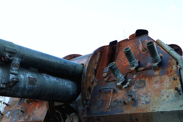 Rusted military tank barrel and turret against white sky © ForStock