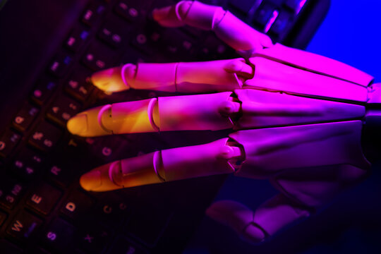 Robotic hand typing on illuminated keyboard