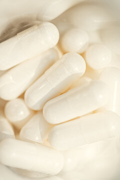 White capsules closeup pile for health and wellness