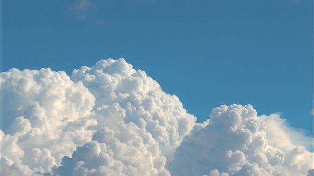 Beautiful white cumulus clouds in a bright blue summer sky