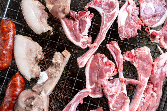 Variety of meats grilling on an outdoor barbecue