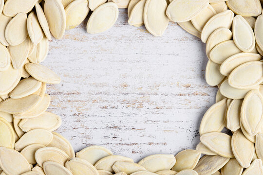 Pumpkin seeds arranged on rustic wooden surface