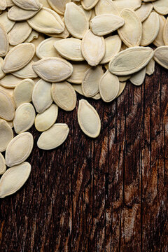 Pumpkin seeds on rustic wooden background