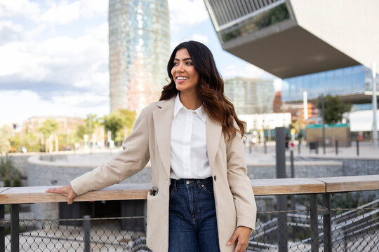 Hispanic businesswoman smiling in urban environment