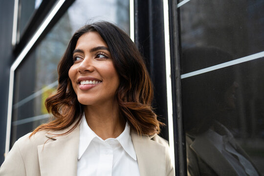 Confident hispanic businesswoman smiling outside