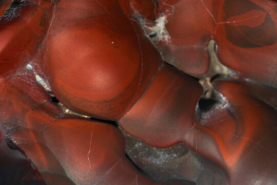 Detailed close-up of vibrant red and brown opal stone surface