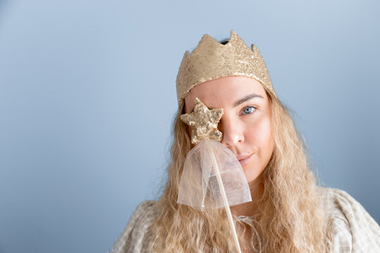 Woman wearing golden crown with magical star wand
