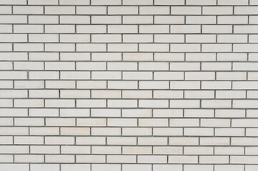 Fototapeta premium White brick wall with gray grout lines in a modern interior setting