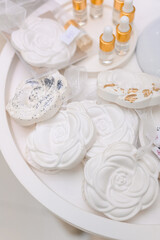 Decorative white rose-shaped soaps with essential oil bottles on display